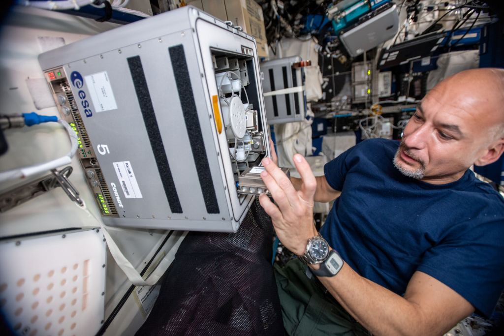 Immagine di un astronauta che carica l'esperimento BioRock nella ISS.